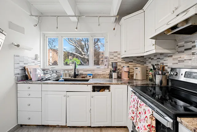 a kitchen with granite countertop a sink stainless steel appliances and cabinets
