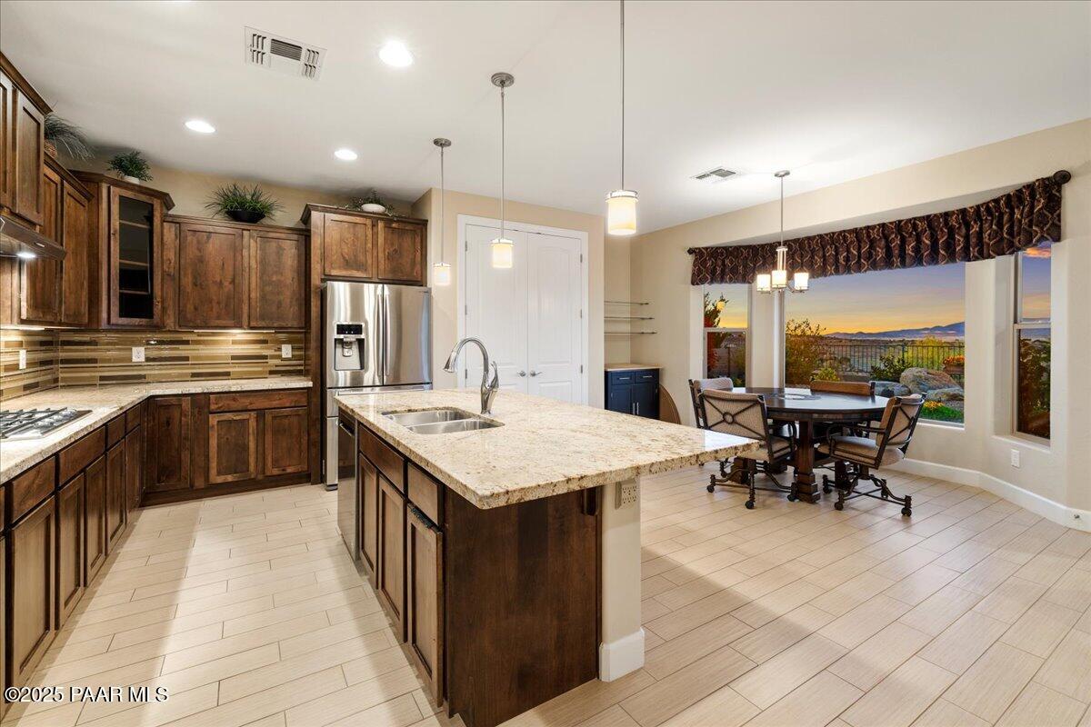 1149 Stack Rock Road Prescott Valley, AZ 86314 - Photo 16 of 85 a kitchen with kitchen island a sink table and chairs