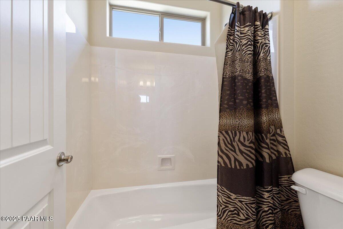 1149 Stack Rock Road Prescott Valley, AZ 86314 - Photo 31 of 85 a bathroom with a toilet and a shower curtain