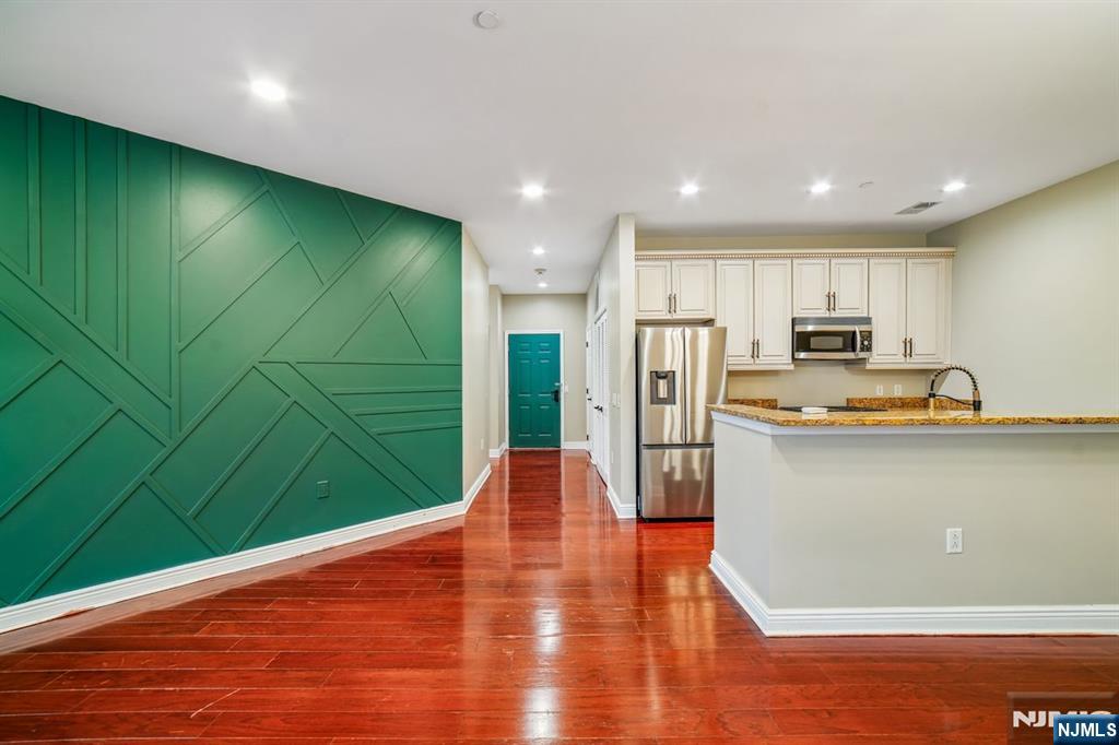 a view of kitchen with kitchen island a counter top space cabinets and stainless steel appliances