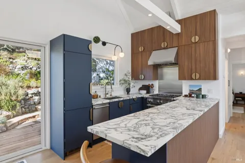 a kitchen with granite countertop a refrigerator a stove a sink dishwasher and wooden cabinets with wooden floor