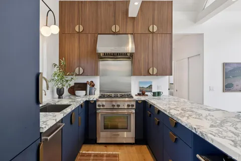 a kitchen with granite countertop a sink stainless steel appliances and cabinets
