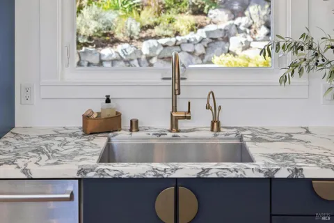 a kitchen with stainless steel appliances kitchen island granite countertop a sink stove and refrigerator