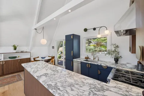 a kitchen with a stove a refrigerator and wooden floor