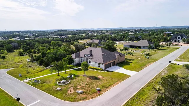 an aerial view of a house with swimming pool and lake view