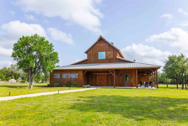 a front view of a house with swimming pool and porch with furniture