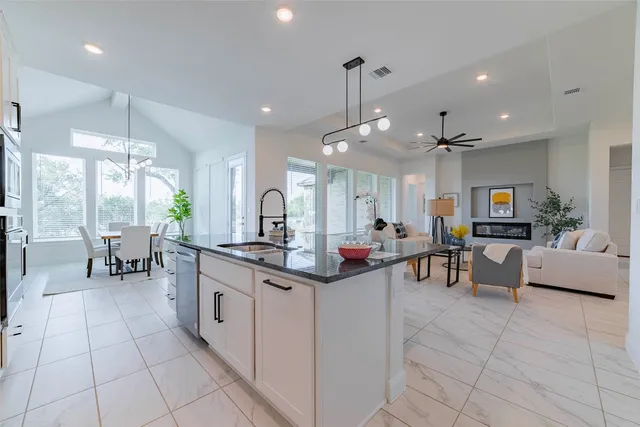 a kitchen with stainless steel appliances kitchen island granite countertop a table and chairs in it
