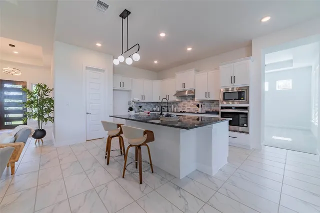 a kitchen with stainless steel appliances kitchen island granite countertop a sink and cabinets