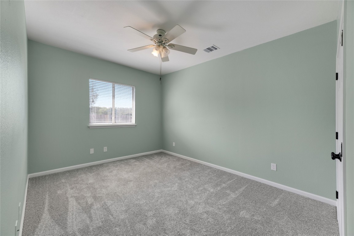 136 Shenandoah Trail Elgin, TX 78621 - Photo 15 of 27 an empty room with a chandelier fan and windows
