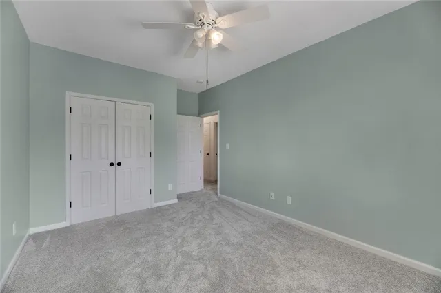 an empty room with a ceiling fan and a window