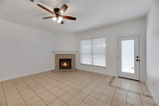 an empty room with fireplace and fan