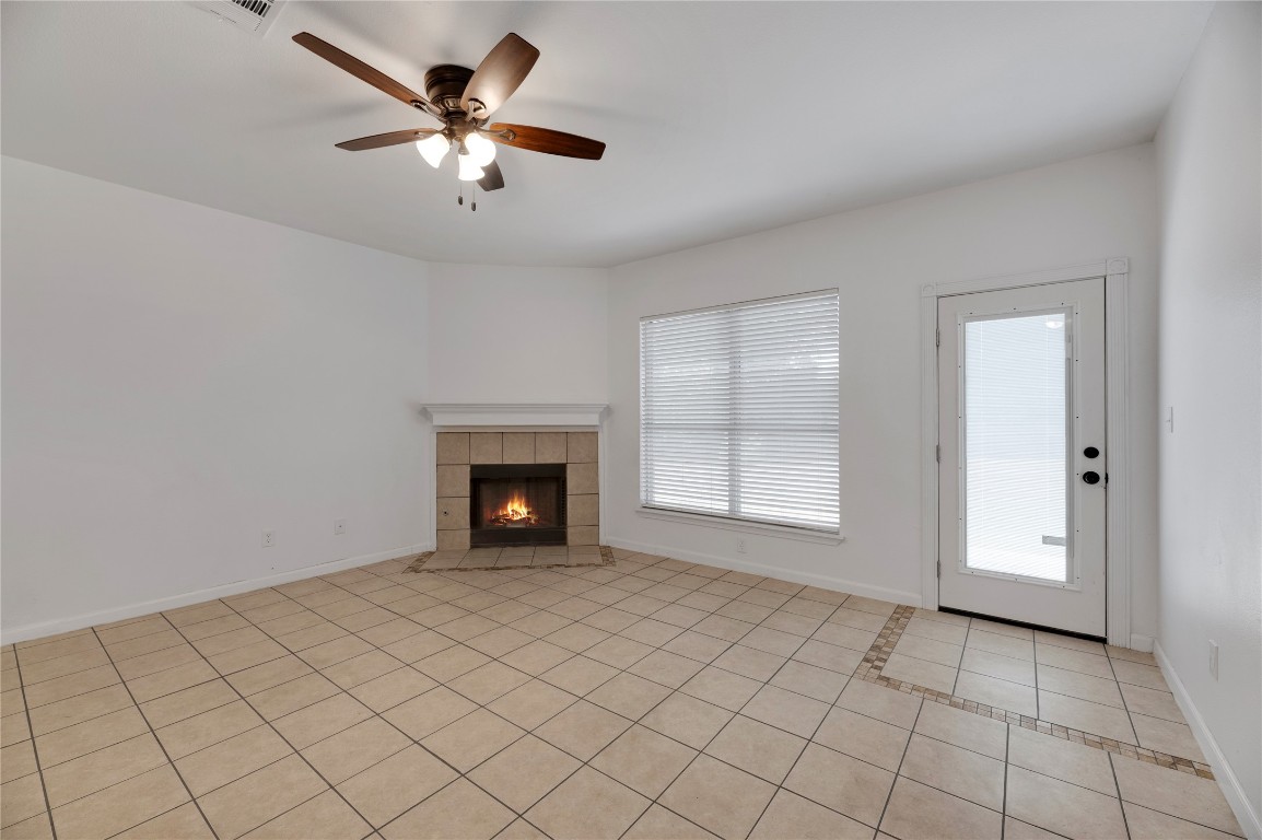 136 Shenandoah Trail Elgin, TX 78621 - Photo 2 of 27 an empty room with fireplace and fan