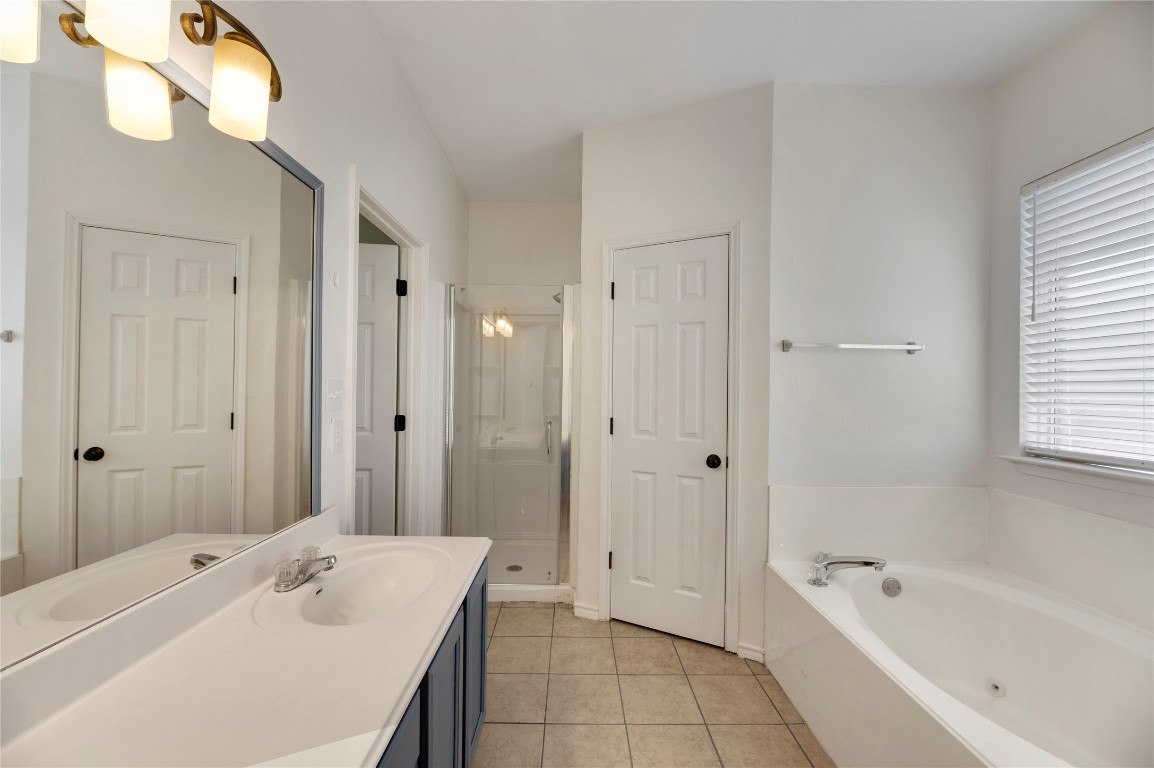 136 Shenandoah Trail Elgin, TX 78621 - Photo 22 of 27 a bathroom with a tub sink shower and mirror