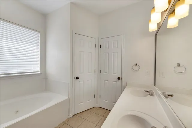 a spacious bathroom with a tub shower and sink