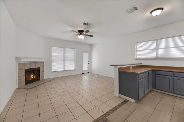 a view of an empty room with a fireplace and a window