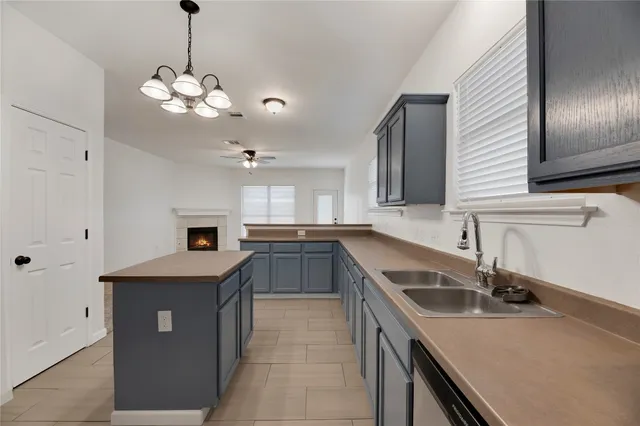 a kitchen with a sink a center island and stainless steel appliances
