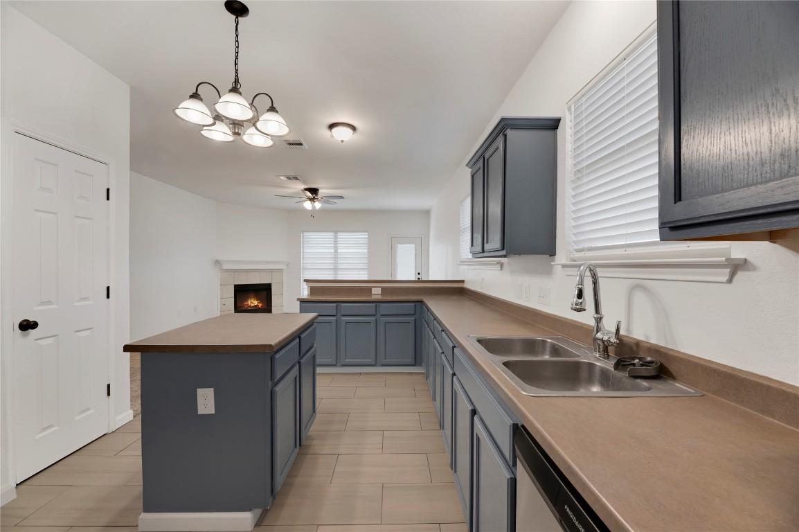 136 Shenandoah Trail Elgin, TX 78621 - Photo 7 of 27 a kitchen with a sink a center island and stainless steel appliances
