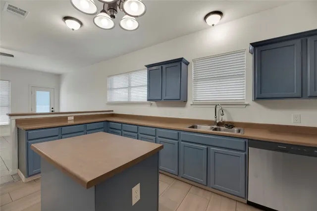 a kitchen with cabinets appliances a sink and a window