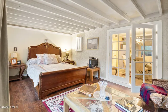 a kitchen with a refrigerator a stove a sink dishwasher a dining table and with wooden floor