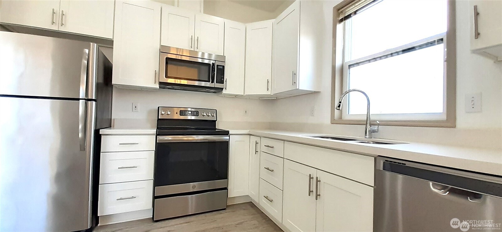 5501 Wilson Avenue South Seattle, WA 98118 - Photo 5 of 12 a kitchen with white cabinets and stainless steel appliances