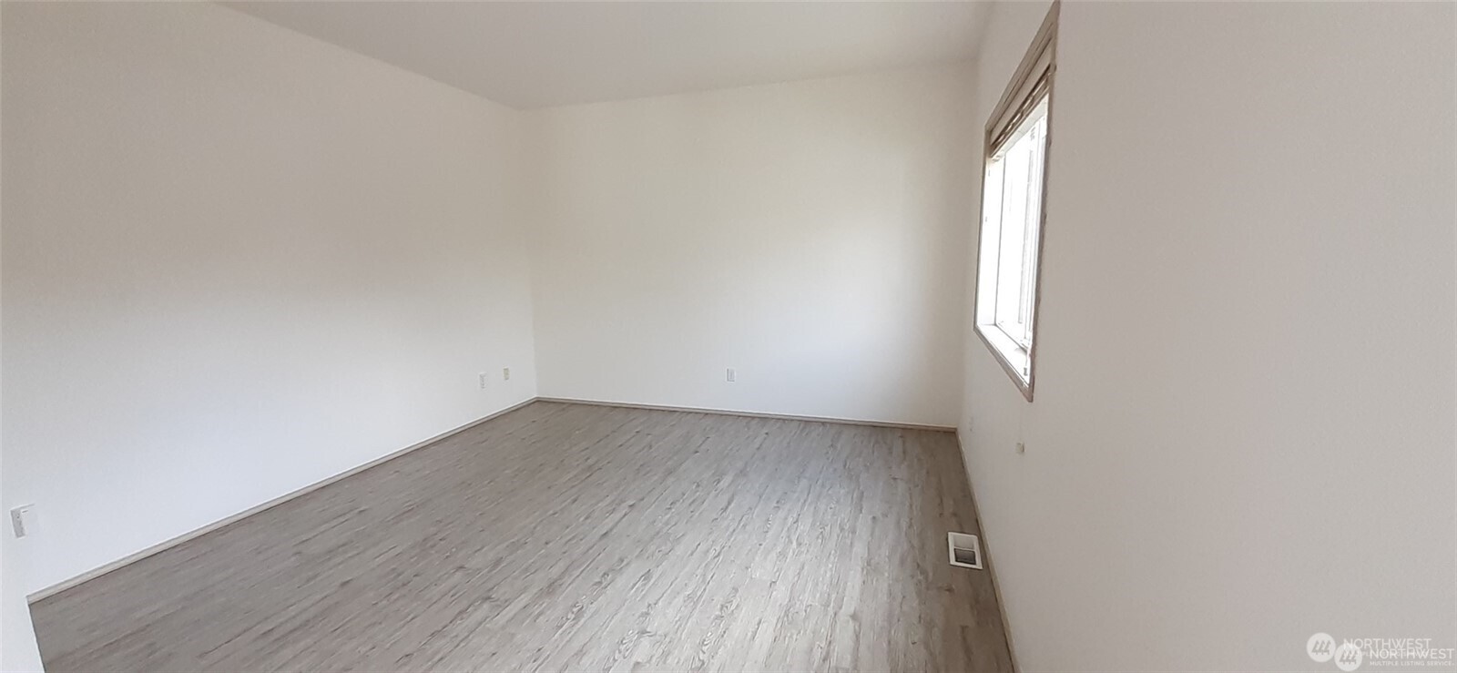 5501 Wilson Avenue South Seattle, WA 98118 - Photo 7 of 12 an empty room with wooden floor and windows
