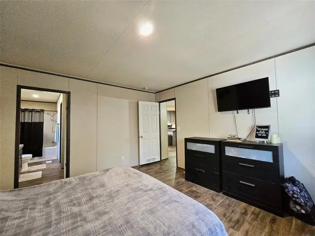 a bedroom with a bed and a flat screen tv