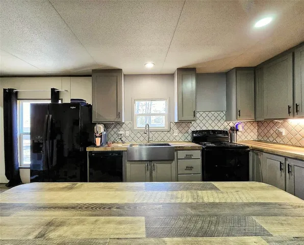 a kitchen with granite countertop a refrigerator stove and sink