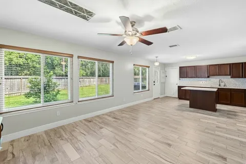 a kitchen with stainless steel appliances granite countertop a stove a sink dishwasher and a refrigerator with wooden floor