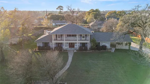an aerial view of a house with swimming pool next to a yard