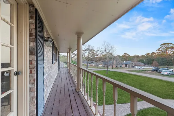 a view of a balcony with wooden floor and fence