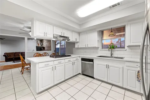 a kitchen with cabinets appliances a sink and a counter top space