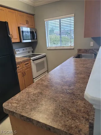 a kitchen with a stove refrigerator and microwave