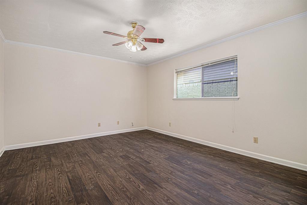 1814 Addington Drive Carrollton, TX 75007 - Photo 19 of 24 Empty room with ornamental molding, dark hardwood / wood-style flooring, and ceiling fan