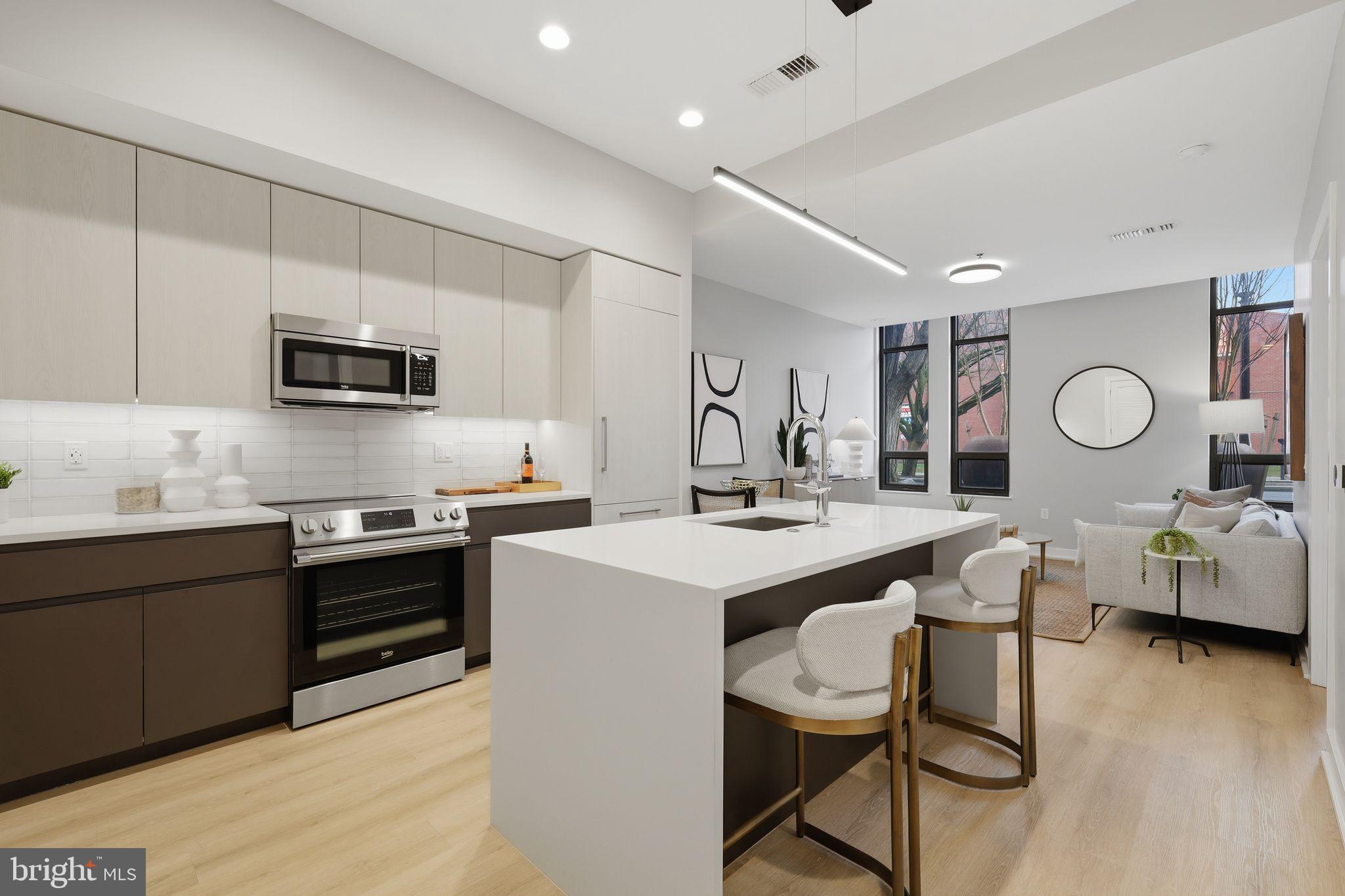 950 3rd Street Northwest, Unit 103 Washington, DC 20001 - Photo 23 of 32 a kitchen with stainless steel appliances kitchen island granite countertop a sink and cabinets