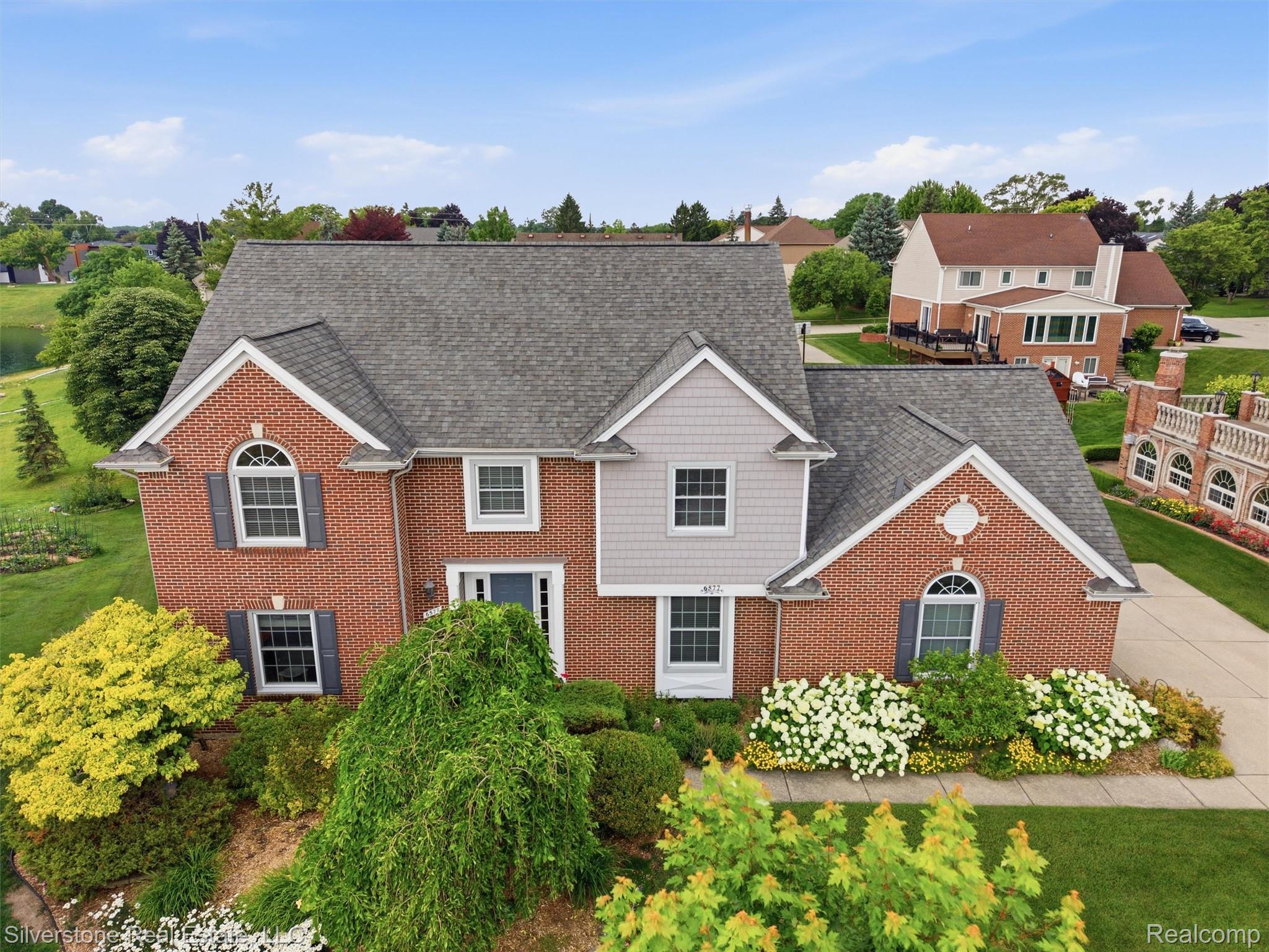 6577 Edith Court Troy, MI 48085 - Photo 5 of 61 Brick and siding exterior featuring a prominent gabled roofline