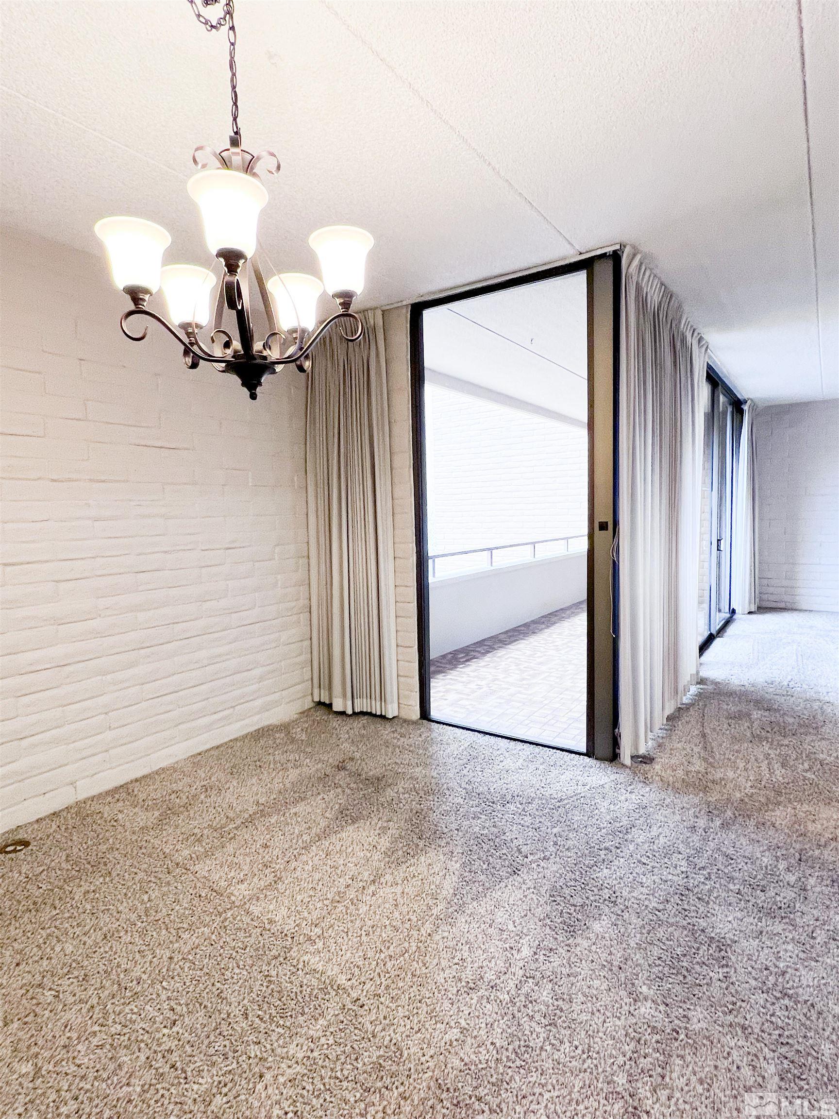 1200 Riverside Drive, Unit 1239 Reno, NV 89503 - Photo 14 of 35 an empty room with a chandelier fan and windows