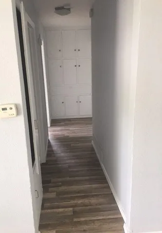 a view of a hallway with wooden floor and entryway