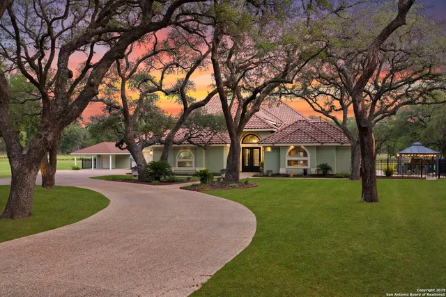 a front view of a house with a garden and trees