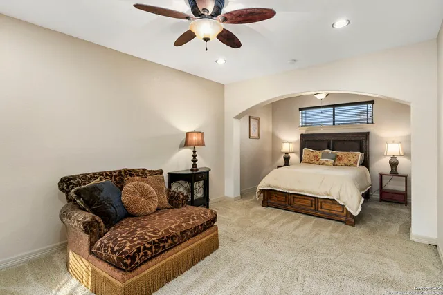 a spacious bedroom with a bed and a chandelier