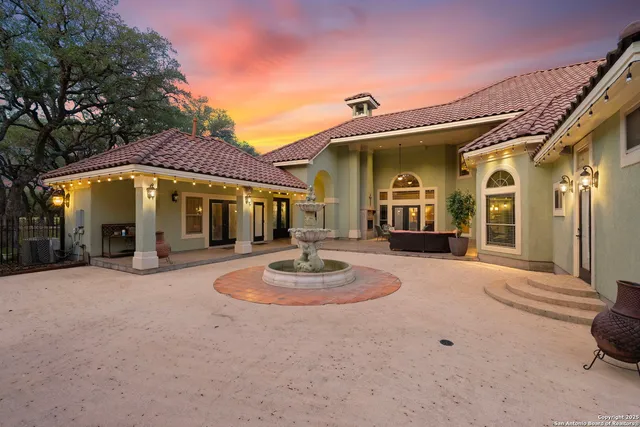 a view of a white building with a fountain in front of it