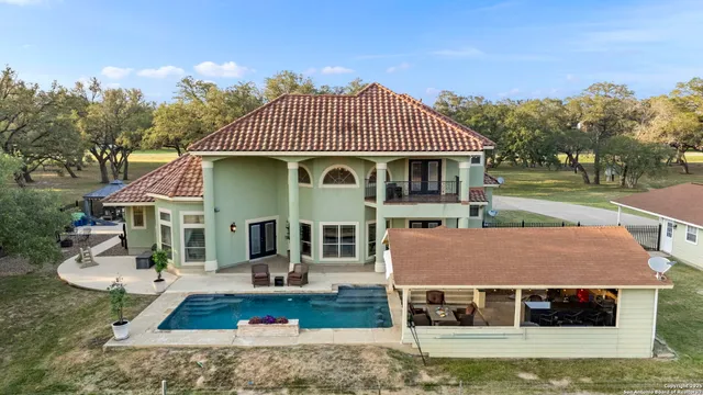 an aerial view of a house with a yard and pool