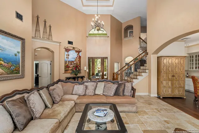 a dining room with furniture a chandelier and wooden floor