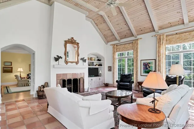 a kitchen that has a sink a microwave oven a stove and white cabinets with wooden floor