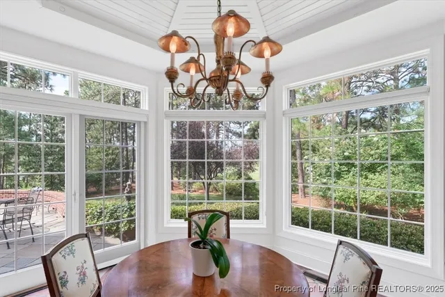 a living room with furniture a chandelier a window and a flat screen tv