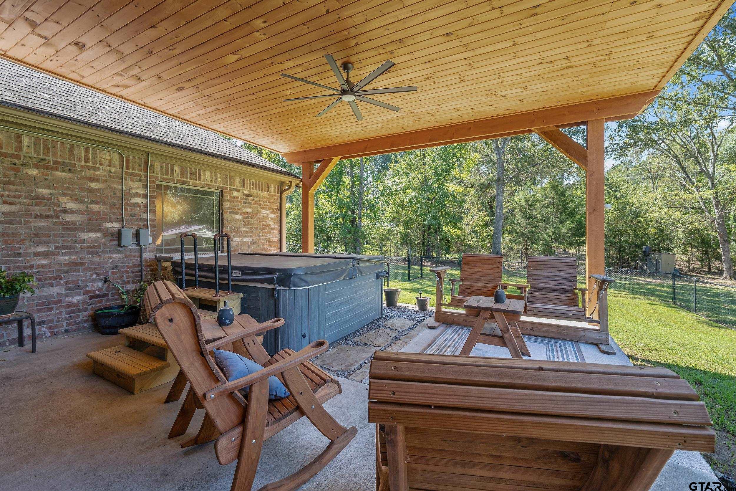 140 Creek Drive Marshall, TX 75672 - Photo 24 of 35 a view of a patio with a table chairs and a backyard