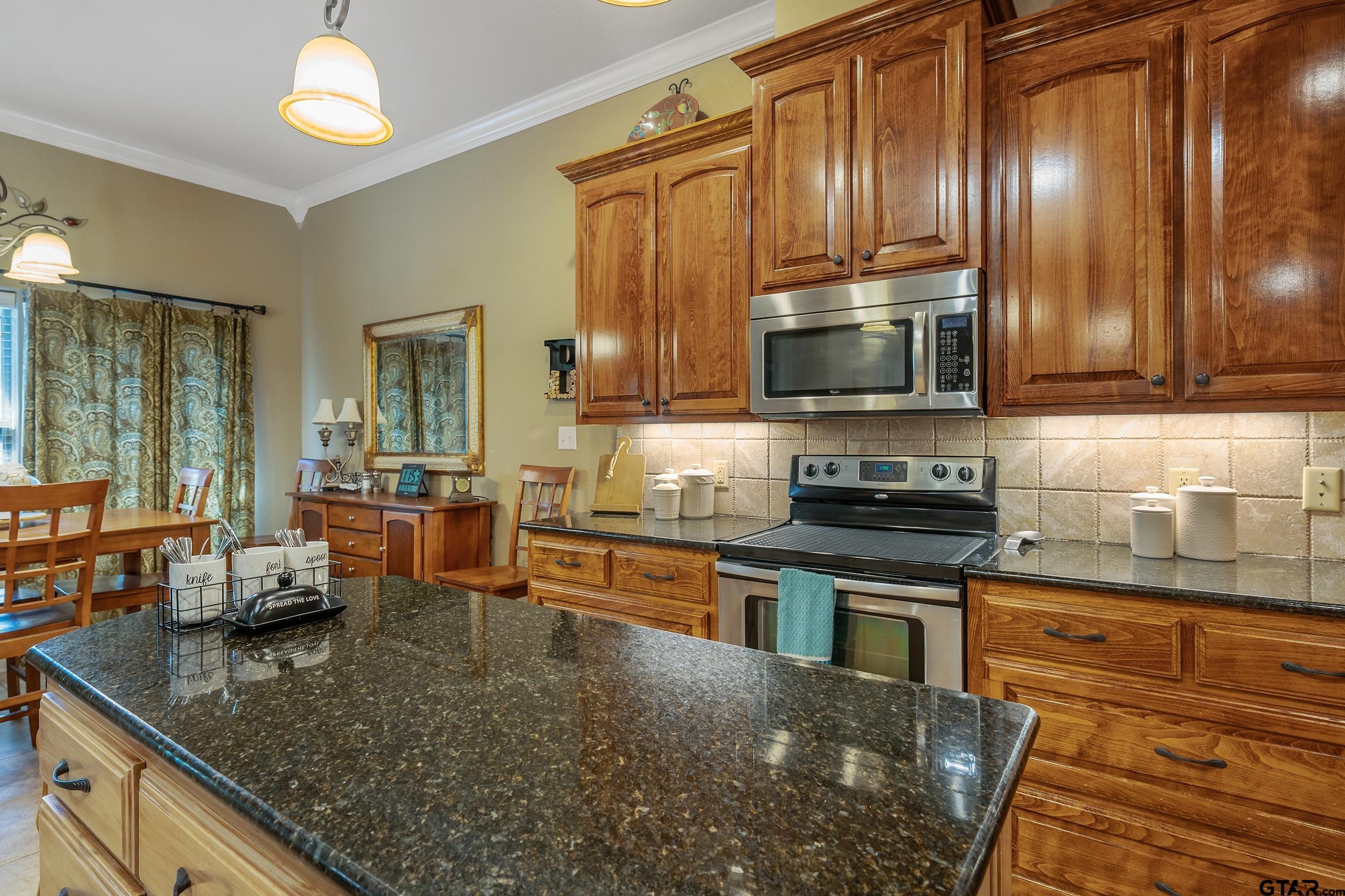 140 Creek Drive Marshall, TX 75672 - Photo 9 of 35 a kitchen with stainless steel appliances granite countertop a stove a sink and a microwave