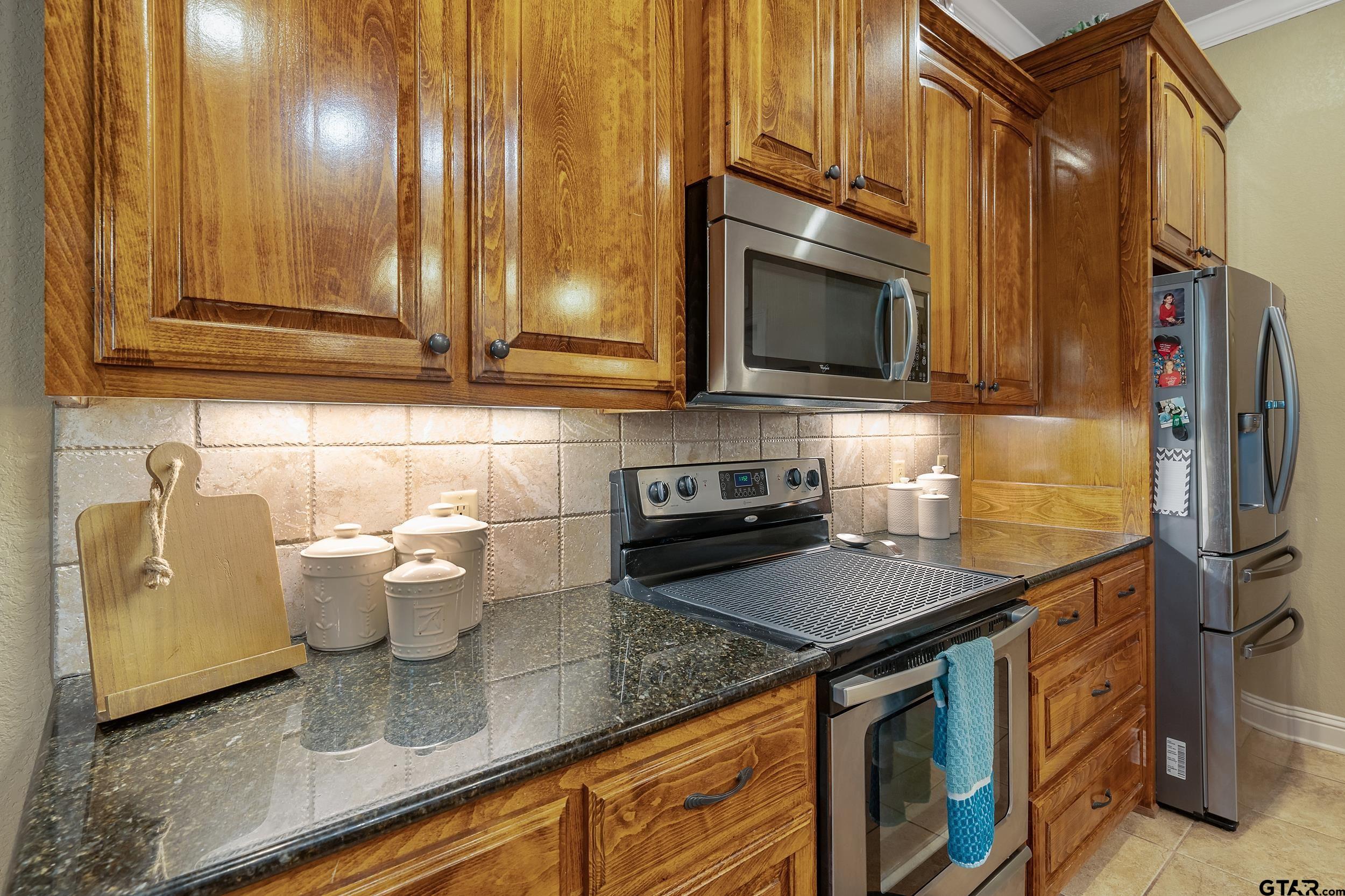140 Creek Drive Marshall, TX 75672 - Photo 10 of 35 a kitchen with stainless steel appliances granite countertop a sink a stove and cabinets