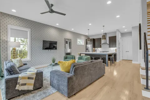 a living room with furniture and a view of kitchen