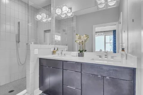 a bathroom with a shower a sink a toilet and mirror