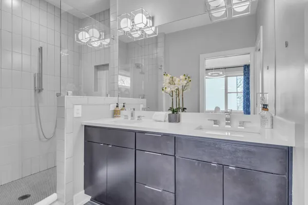 a bathroom with a shower a sink a toilet and mirror